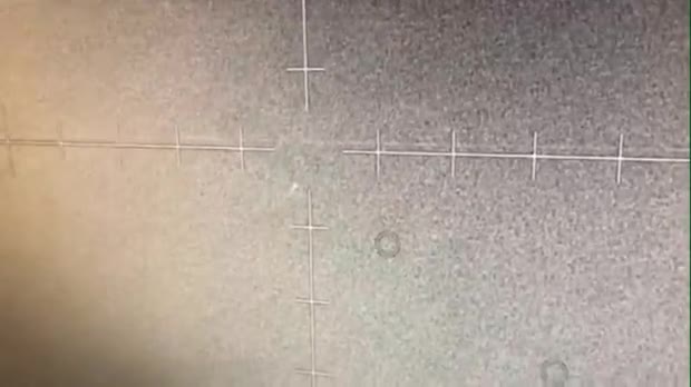 Infrared sensor screen from an AC-130J gunship showing crosshairs and faint circular objects